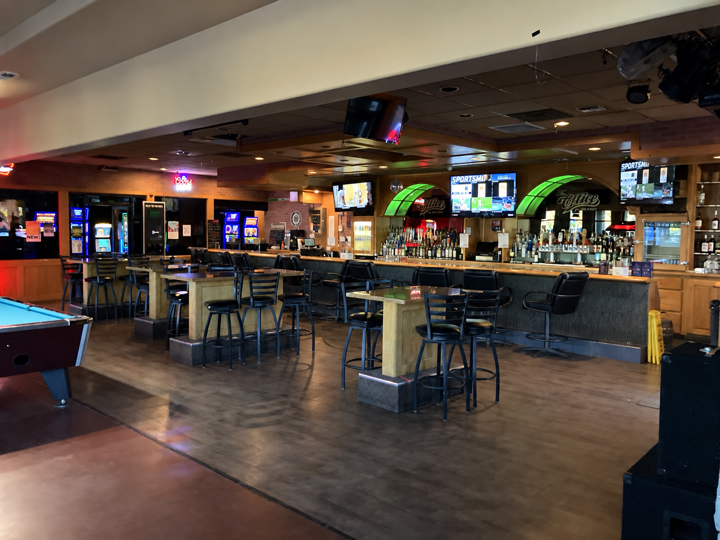 The Office bar with televisions, beer taps, and seating